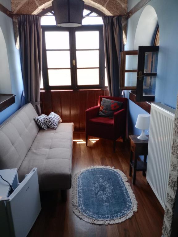 a living room with a couch and a chair at Soul boutique hotel in Monodendri