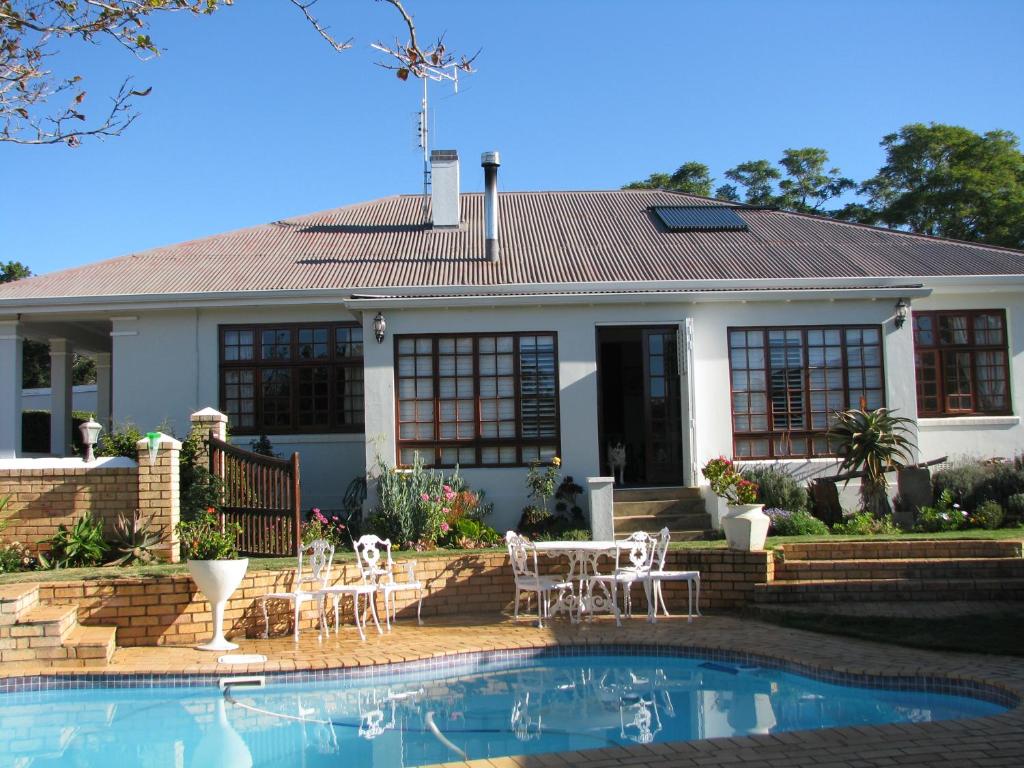 a house with a swimming pool in front of a house at Kaiser's B&B in Grahamstown