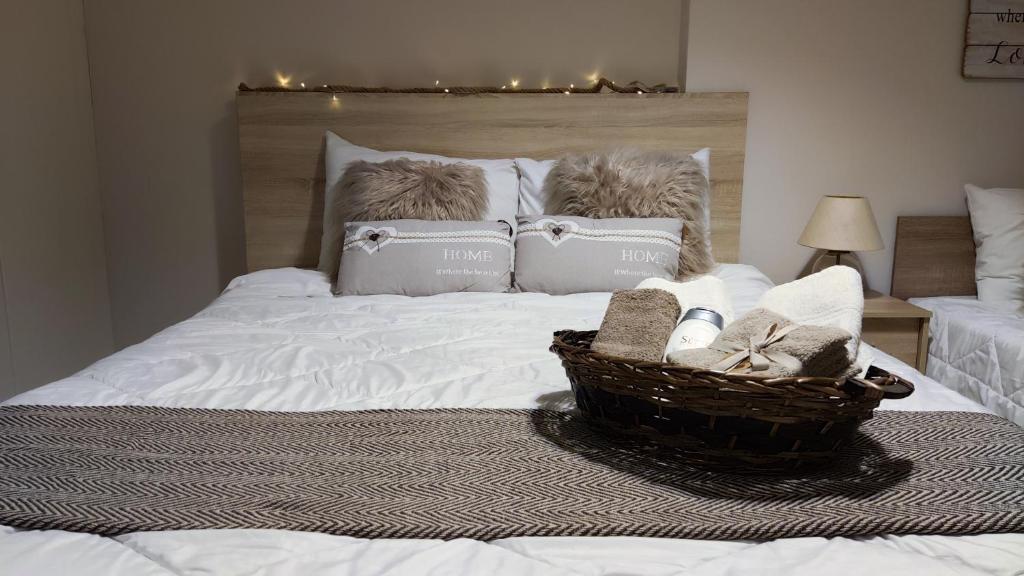 a white bed with a basket of towels on it at Rock & Roll 2 - Modern apartment in Trikala in Tríkala