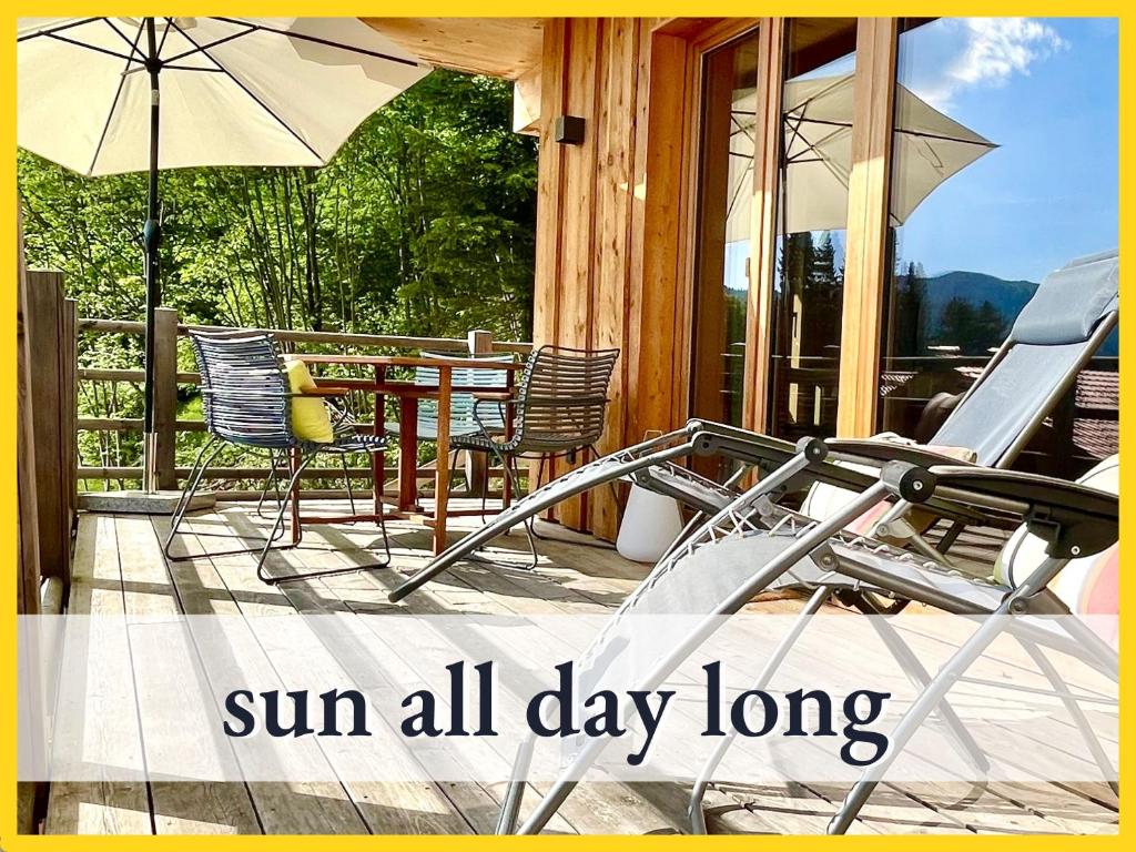 een patio met stoelen en een tafel met een parasol bij Seenähe-Seeblick-Bergblick-Bio, Natur, Bleibe am Berg in Schliersee