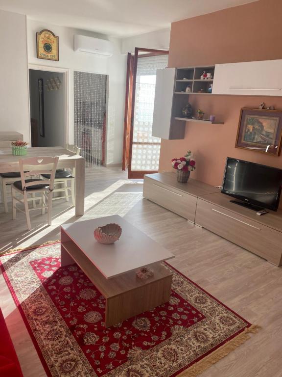 a living room with a table and a dining room at La Casa al Mare di Giulia in Porto Potenza Picena