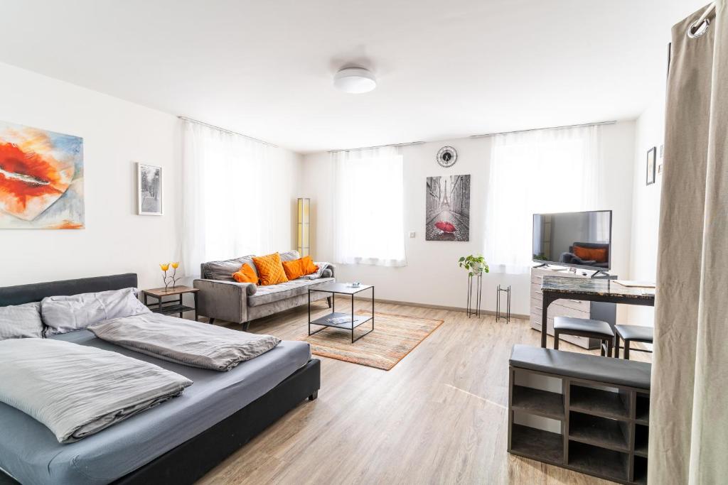 ein weißes Wohnzimmer mit einem Sofa und einem Tisch in der Unterkunft TAGBLATT Apartment 1 in Tuttlingen
