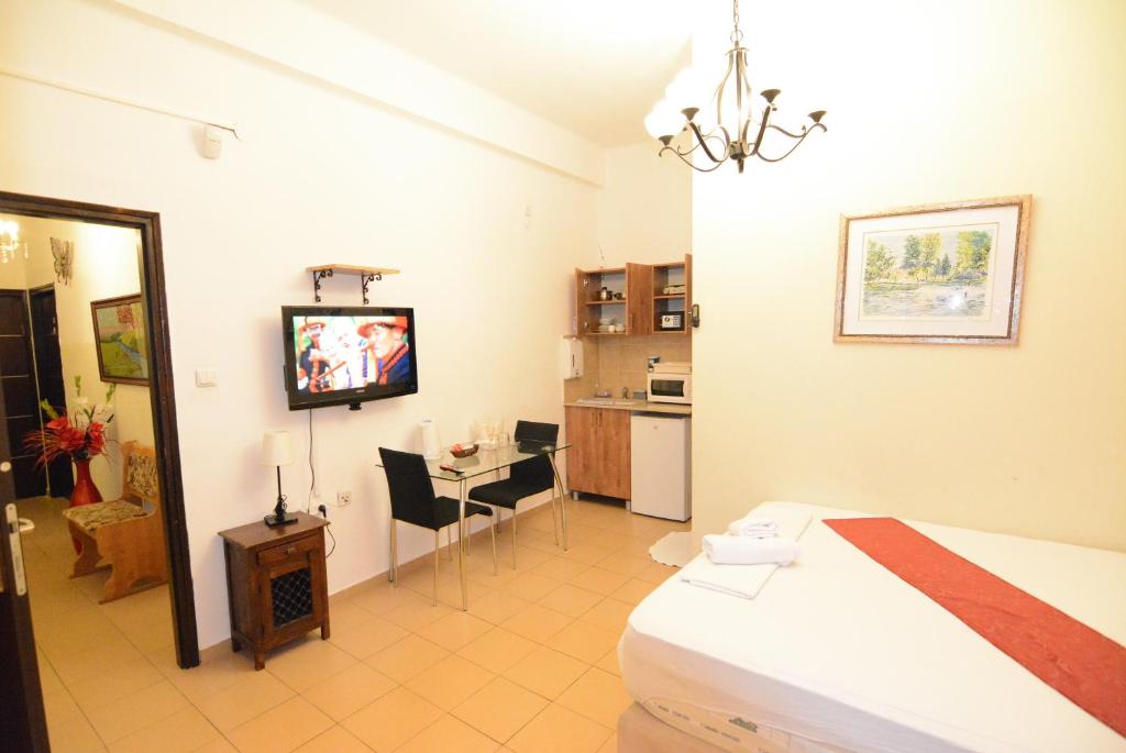 a room with a bed and a table and a kitchen at City Center Apartments in Haifa