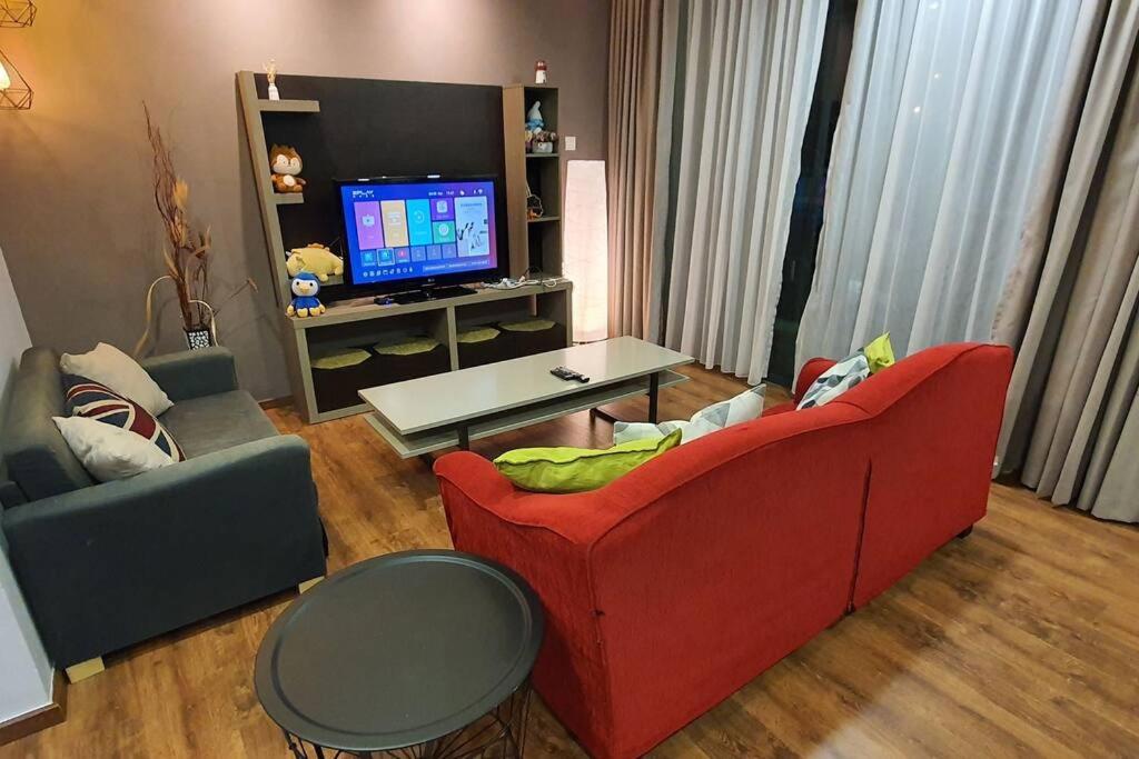a living room with a red couch and a tv at Lovely Jazz 1 3bedrooms with 2 Card LV9 in Kuching