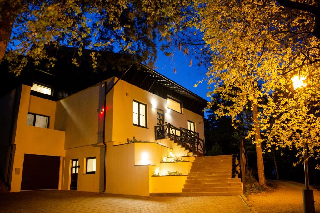 a building with stairs in front of it at night at Dvi Nidos in Nida