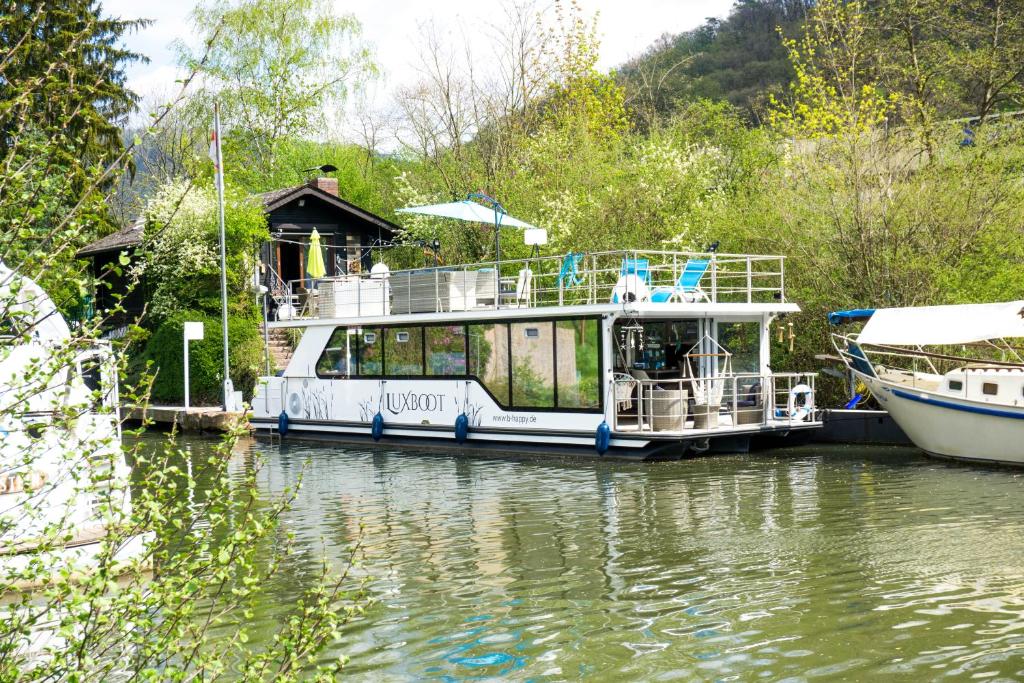 Ein Boot lag auf einem Fluss mit einem Haus darauf. in der Unterkunft Hausboot Schleuseninsel in Lahnstein