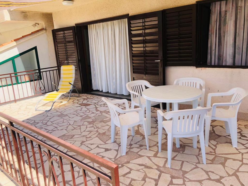 a patio with a table and chairs on a balcony at Apartman Donna in Zaboric
