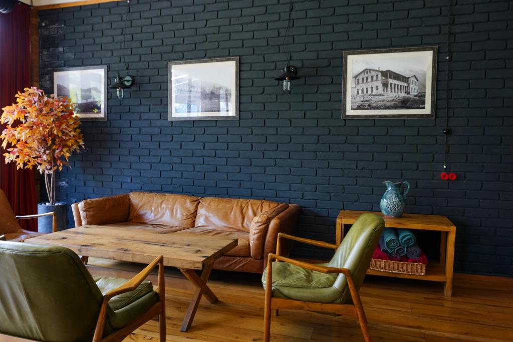 un soggiorno con divano e sedie in pelle di Hotel Stancia Kazbegi - City Center a Kazbegi