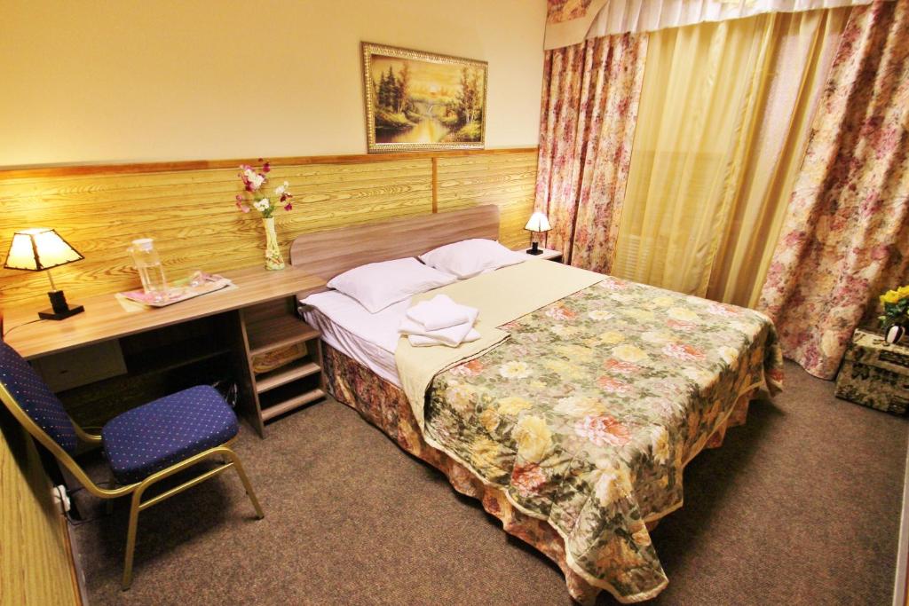 a hotel room with a bed and a desk and a bed sidx sidx at Hotel Nataly on Srednemoskovskaya 7 in Voronezh