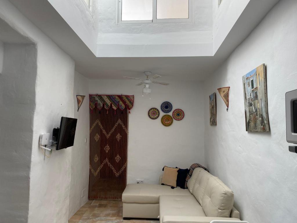 uma sala de estar com um sofá e uma televisão em Cheerful one bedroom townhouse with patio Archez em Árchez