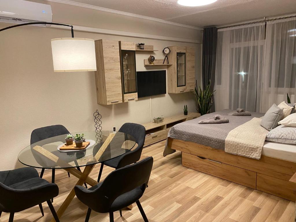 1 dormitorio con 1 cama, mesa y sillas en Centrum Apartman, en Kaposvár