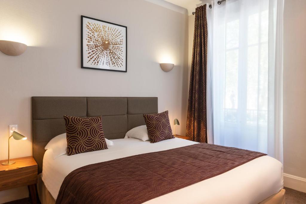 Postel nebo postele na pokoji v ubytování Hôtel Les Nations The Originals Boutique VICHY