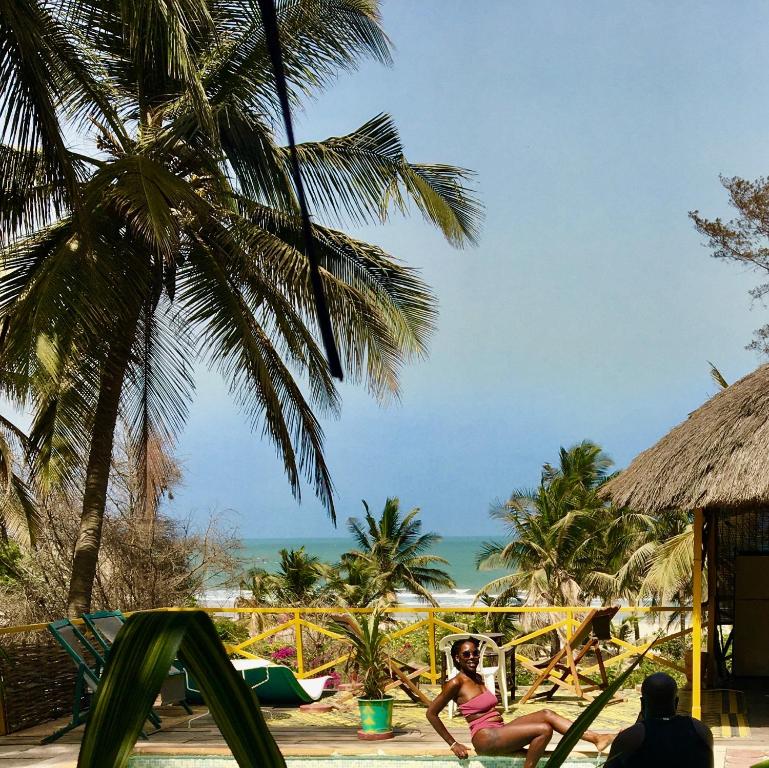 a group of people on a beach with the ocean at SAFARI Lodge Location Bungalow in Cap Skirring
