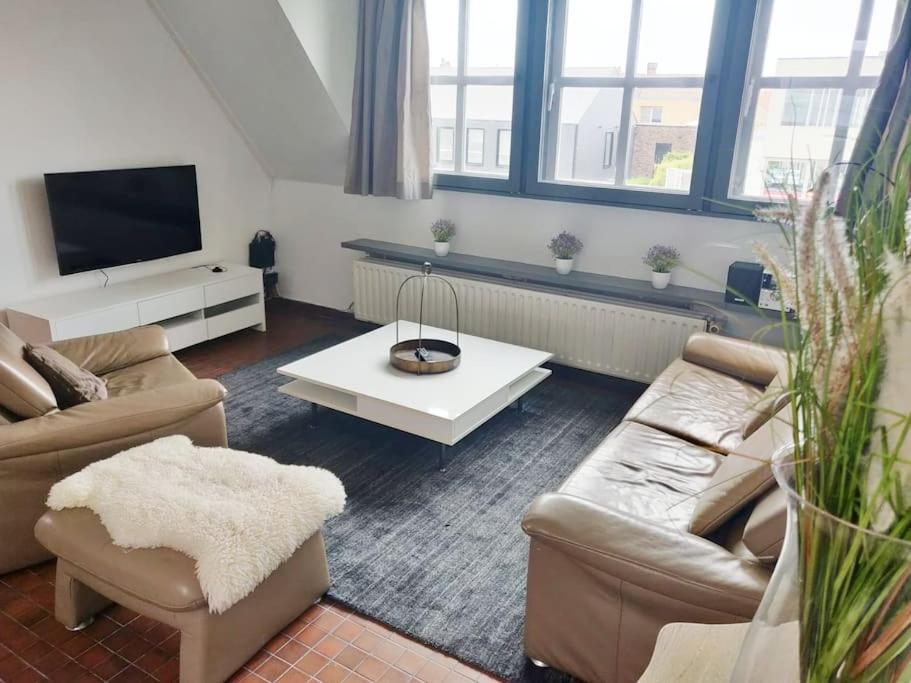 a living room with two couches and a tv at Ontdek Brugge en Vlaanderen! in Zedelgem