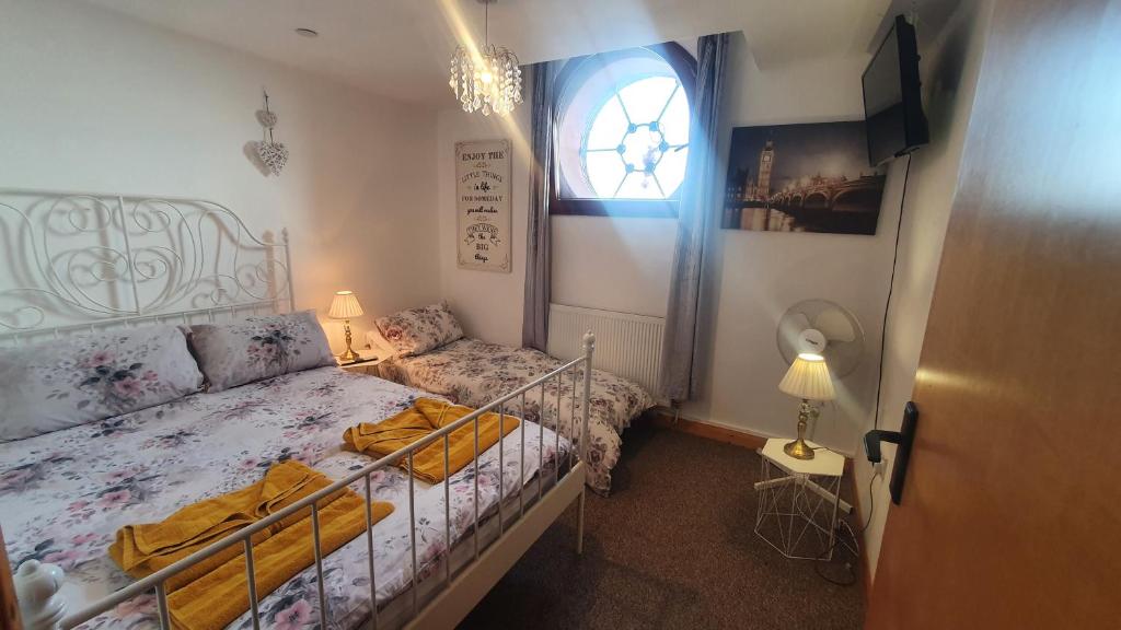 ein kleines Schlafzimmer mit einem Bett und einem Fenster in der Unterkunft Seaside Summer Room in Ramsgate