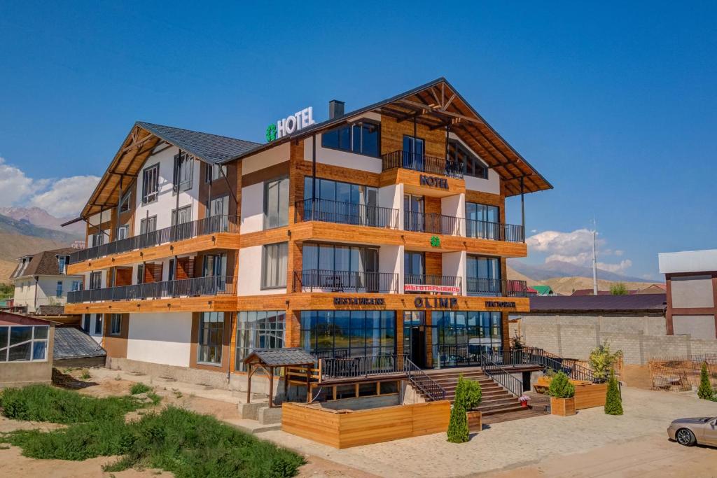 un grand bâtiment avec un panneau en haut dans l'établissement Olimp Hotel, à Bosteri