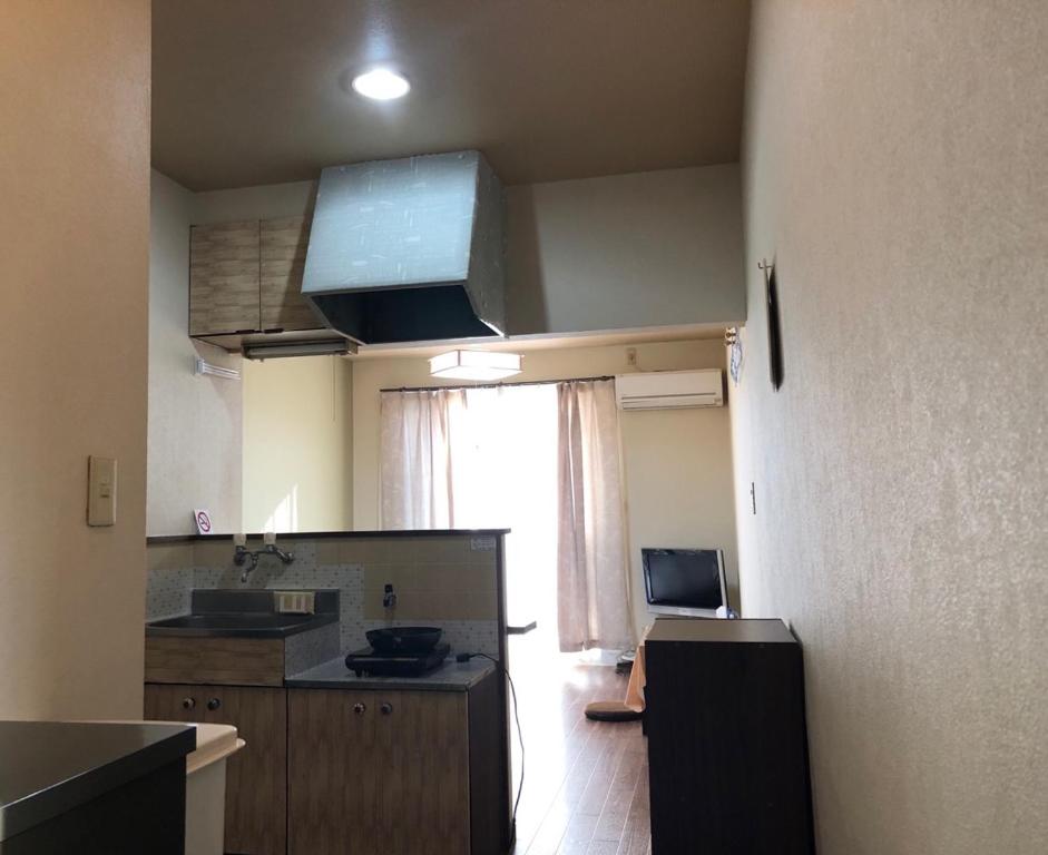 um quarto com uma cozinha com uma grande janela em アルピエa敷地内無料駐車場付き em Kumamoto