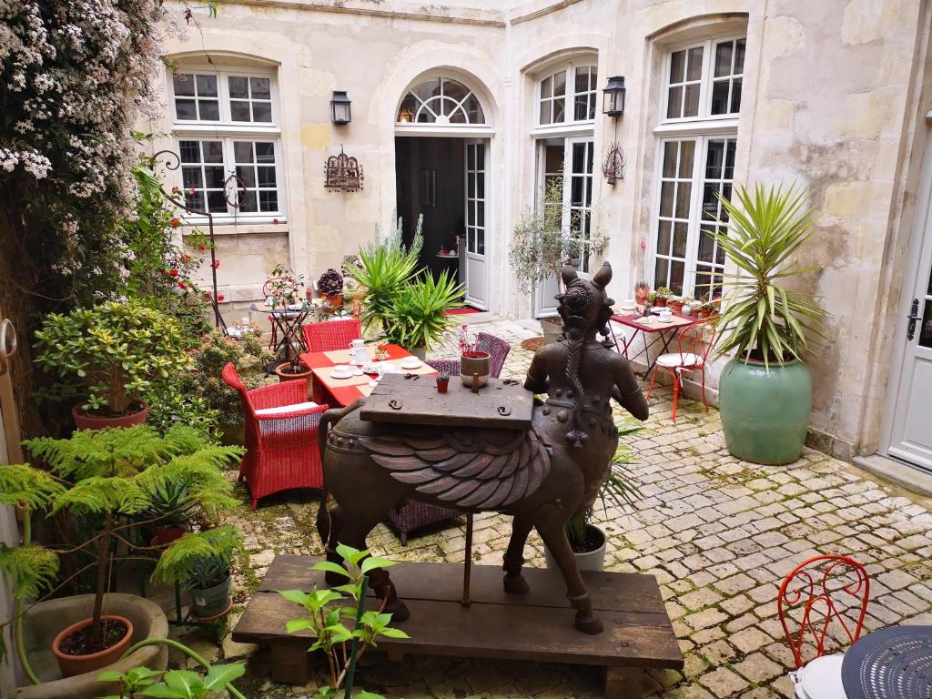 a statue of a woman riding a horse in a courtyard at La Résidence des Indes in La Rochelle