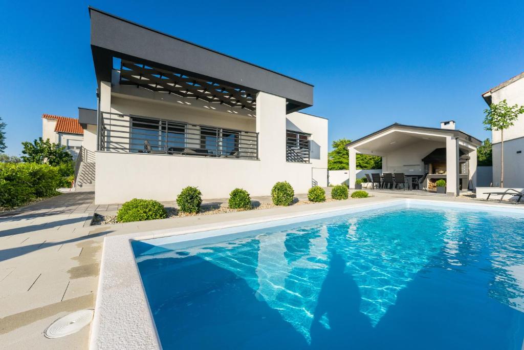 ein Haus mit einem Pool vor einem Haus in der Unterkunft Villa Barbara-holiday home with sea view in Zadar
