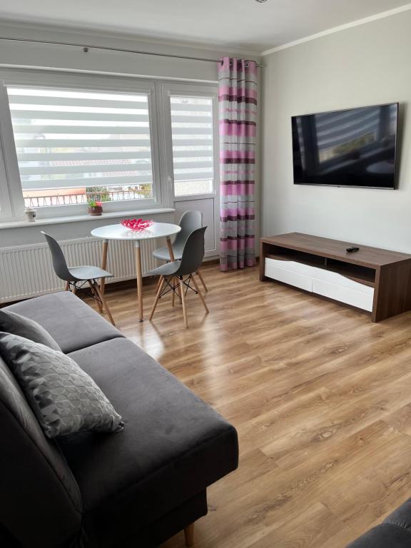 a living room with a couch and a table at Pokoje Gościnne U RYBAKA in Karwia