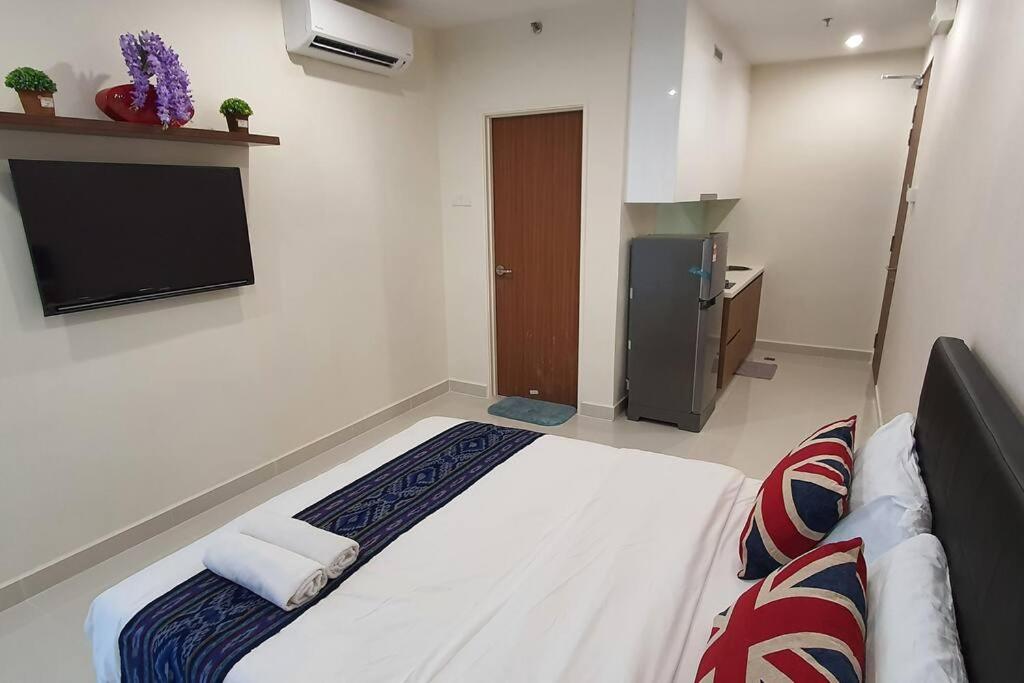 um quarto de hotel com uma cama e uma televisão em Lovely Kozi Square Studio 1 Bedroom with Pool LV9B em Kuching