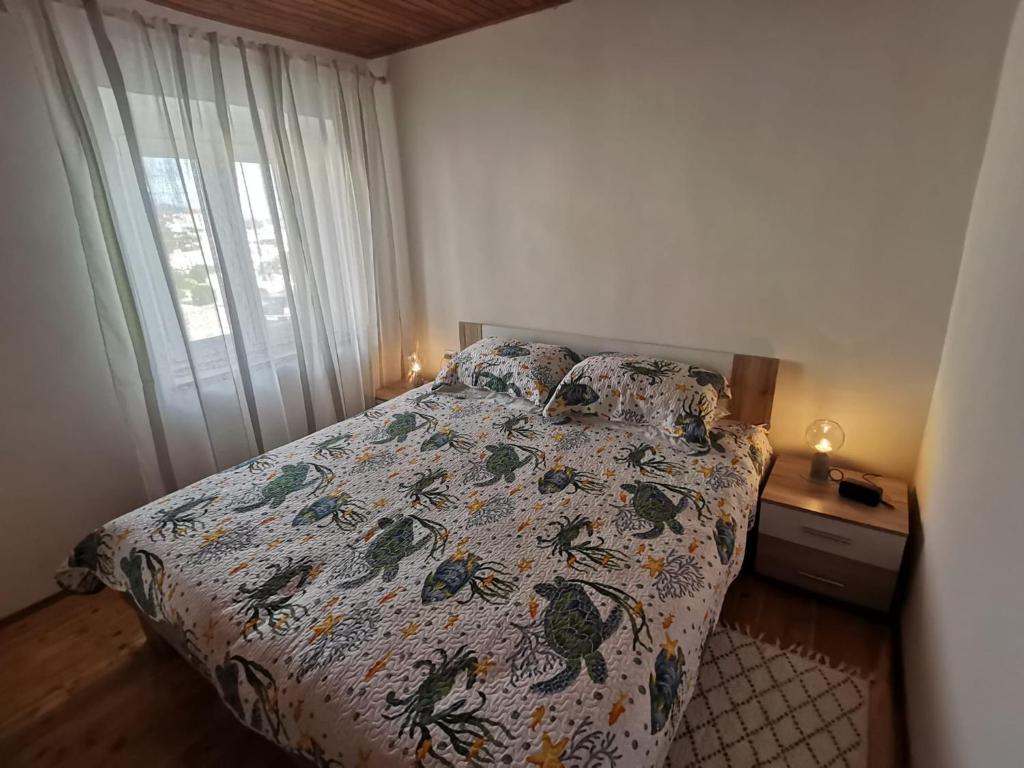 a bedroom with a bed with a comforter and a window at Charming Traditional Townhouse - Holiday Home Kata in Jezera