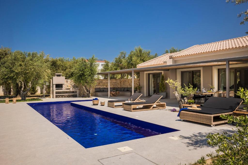 a backyard with a swimming pool and a house at Villa JOYANA in Svoronata