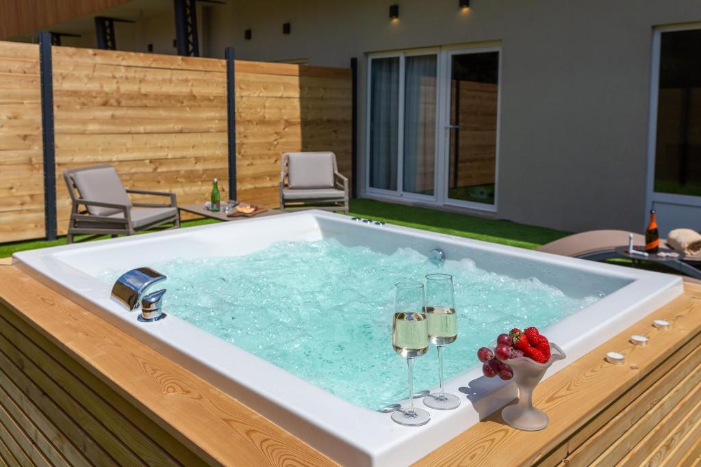 a bath tub with two glasses of wine in it at Zlatni Rat Beach Resort in Bol