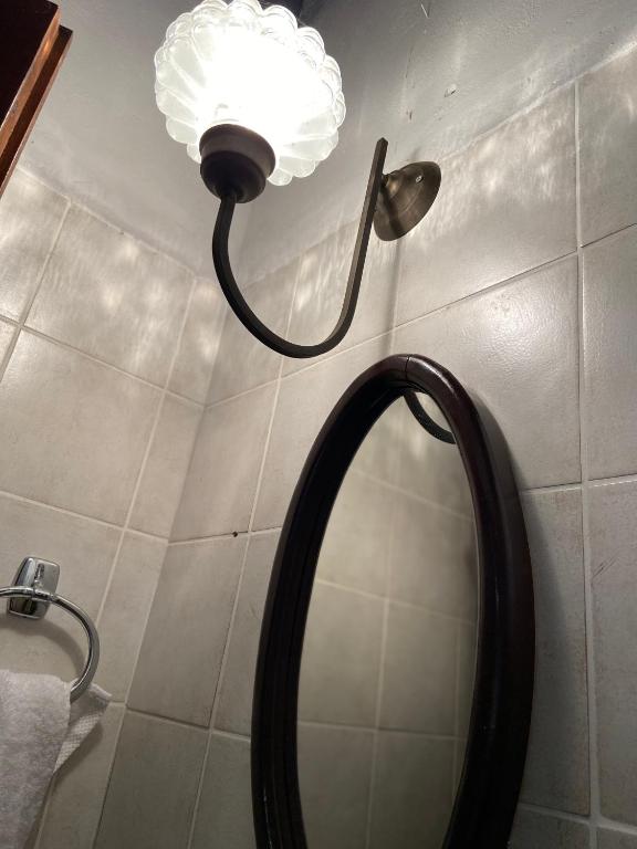 łazienka z lustrem i lampką na ścianie w obiekcie Katouna hill w mieście Leukada (miasto)