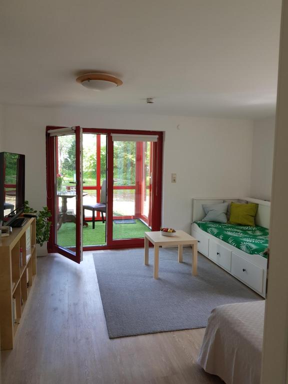 Schlafzimmer mit einem Bett und einem Tisch sowie Glasschiebetüren in der Unterkunft Charmante Einliegerwohnung in Kiel