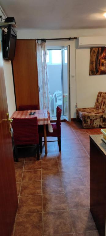 a room with a table and chairs and a living room at Apartman Jasna in Herceg-Novi