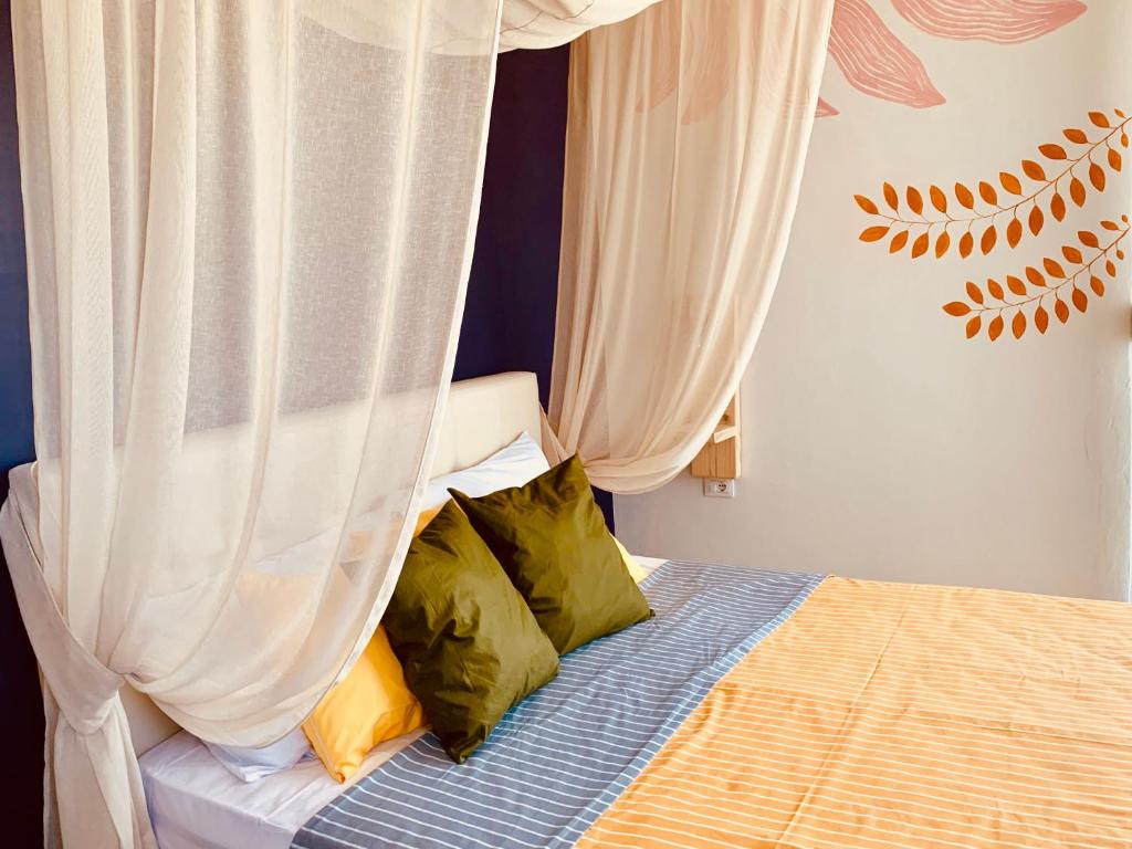 een slaapkamer met een bed met gordijnen en kussens bij Family Tree - quiet area -SELF check in in Golem