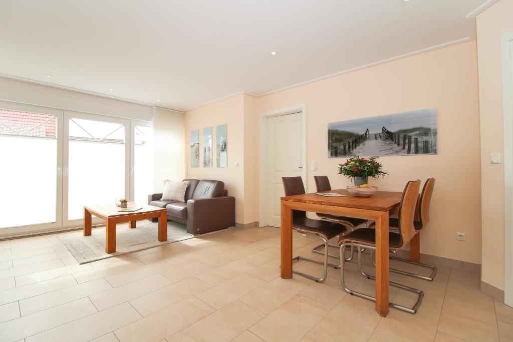 a living room with a table and a couch at Ferienwohnung Kleekamp Norddeich in Norden