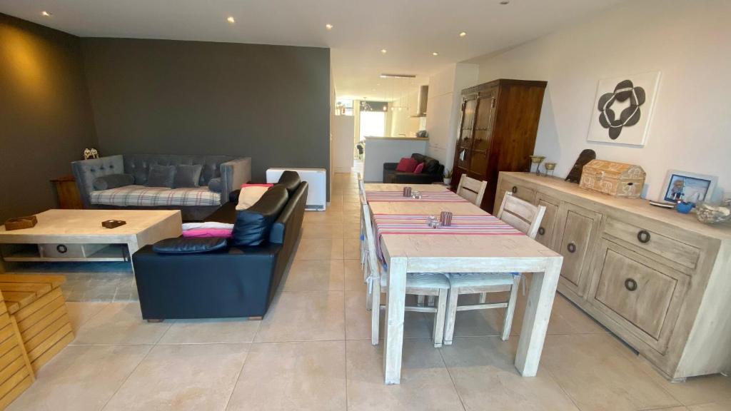 a kitchen with a table and chairs and a couch at Deluxe Apartment with Shared Pool in Ostend