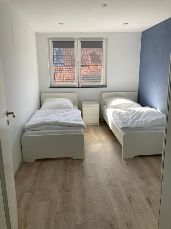 two beds in a room with two windows at Casa Cremer in Übach-Palenberg