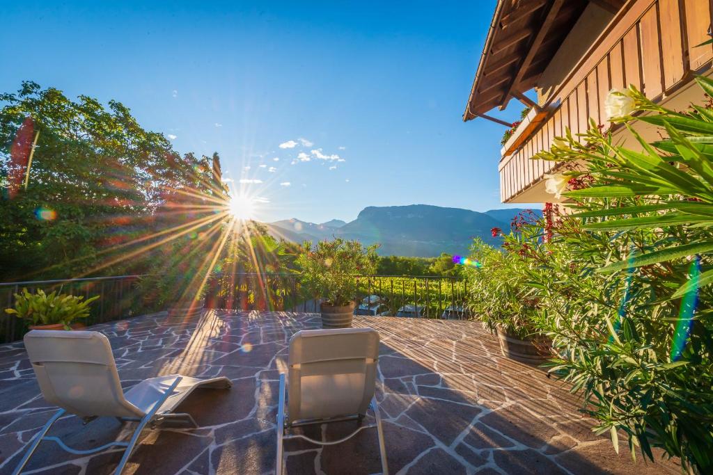 eine Terrasse mit 2 Stühlen und Sonnenschein in der Unterkunft Sandhof in Tramin an der Weinstraße