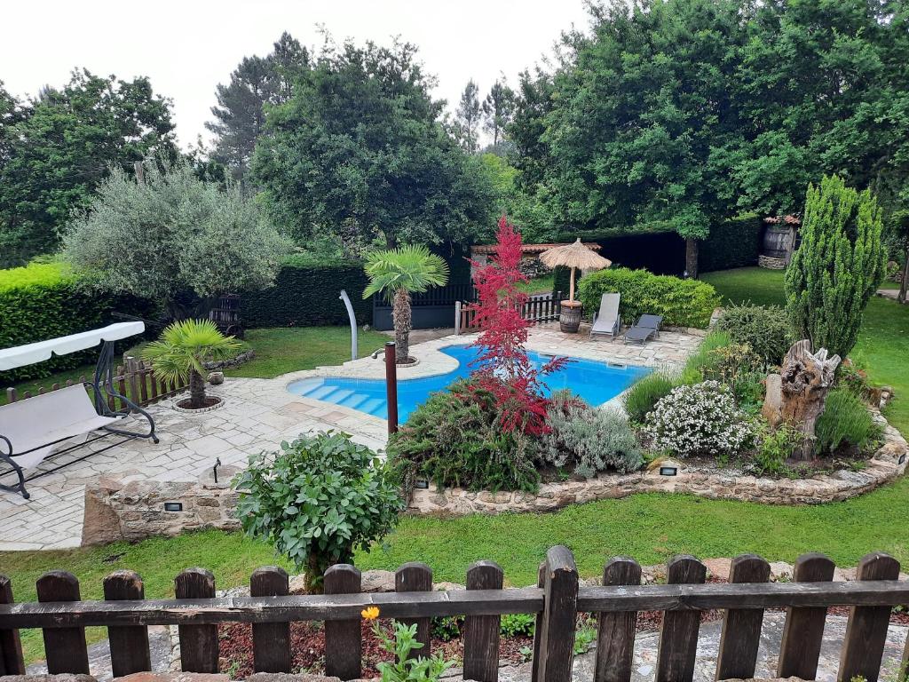 um jardim com uma piscina e uma cerca de madeira em As Alburiñas em Bolmente