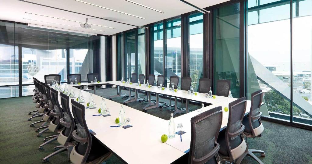 a large conference room with a long table and chairs at Novotel Auckland Airport in Auckland