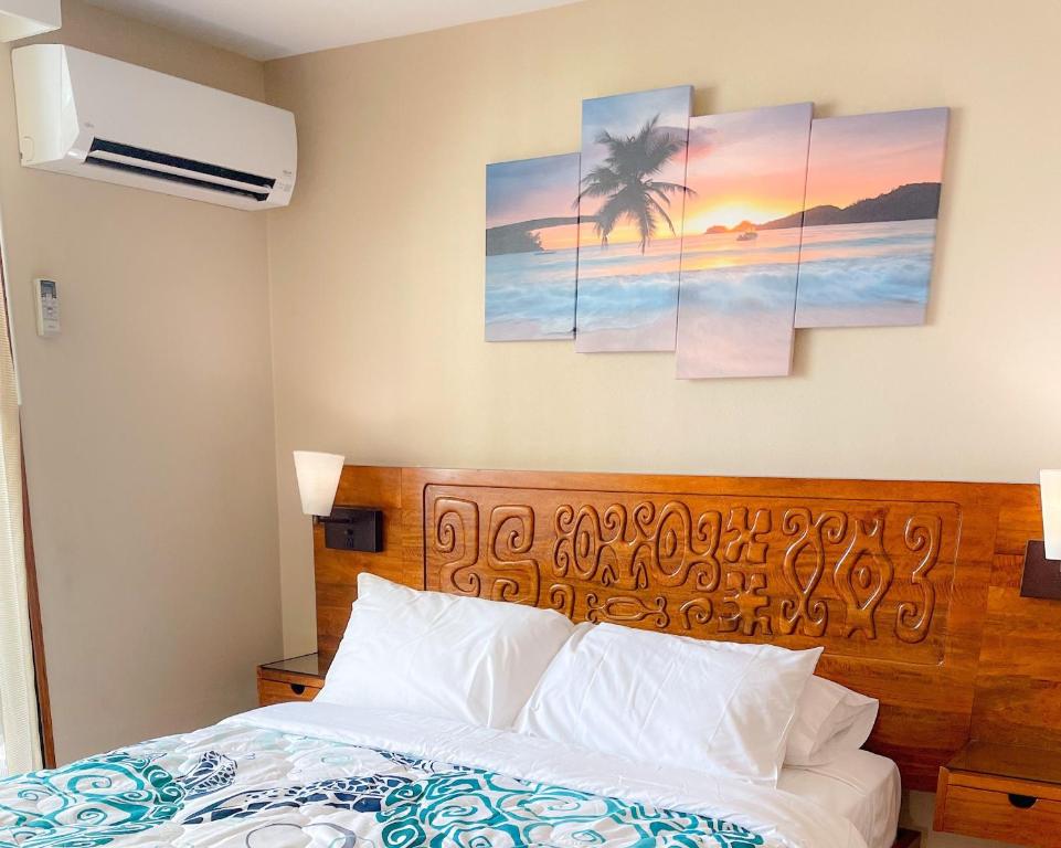 1 dormitorio con 1 cama y algunos cuadros en la pared en Bamboo 1002 condo, en Honolulu