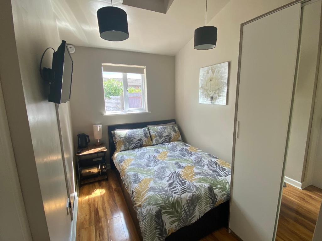 a small bedroom with a bed and a window at Private room and bathroom with private entrance near Warwick town centre in Warwick