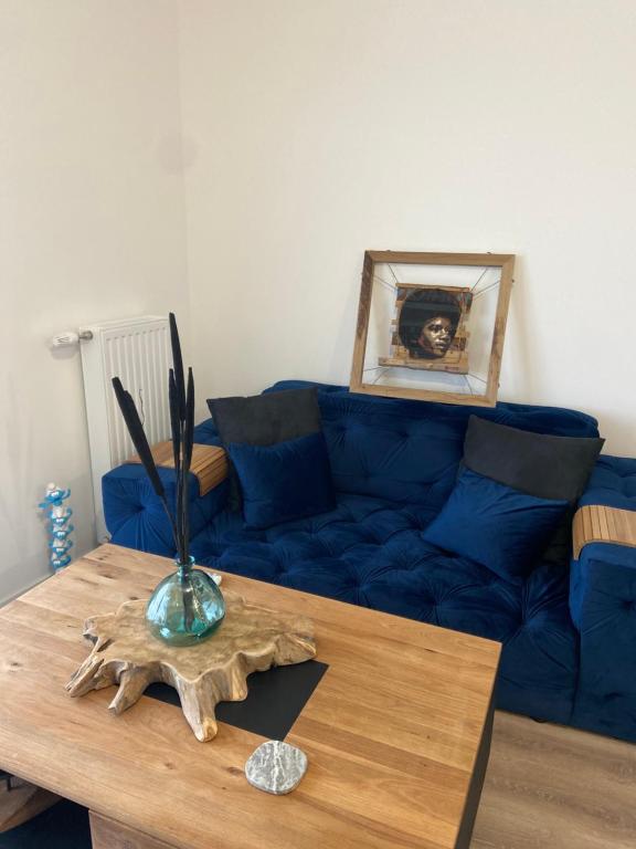 a living room with a blue couch and a table at Le Denecourt - à deux pas de la Gare et de la Forêt de Fontainebleau in Avon