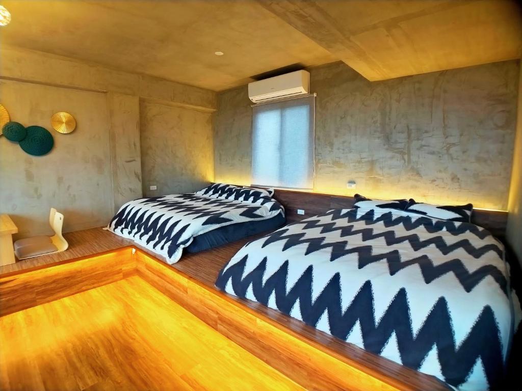 duas camas sentadas uma ao lado da outra num quarto em 海灣旅宿 em Sanzhi
