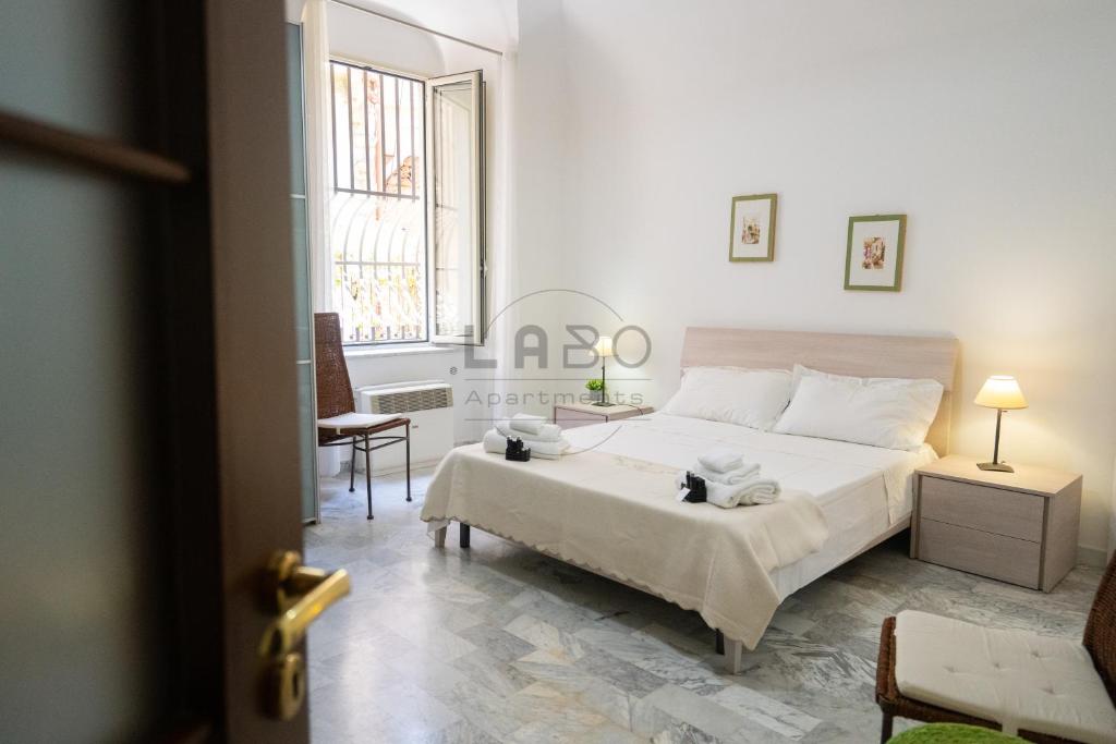 a white bedroom with a bed and a window at Eirene Exclusive Apartment in Tropea