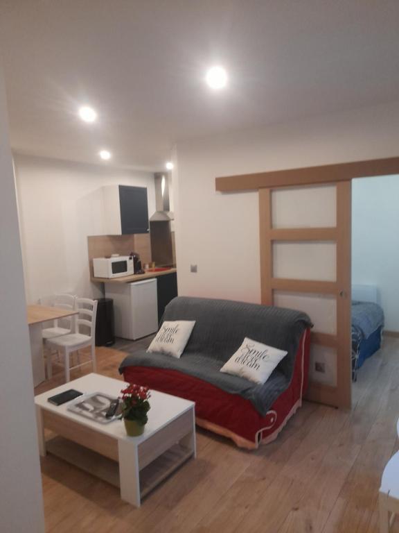 a bedroom with a loft bed and a table at Appartement de l'épée in Dieppe