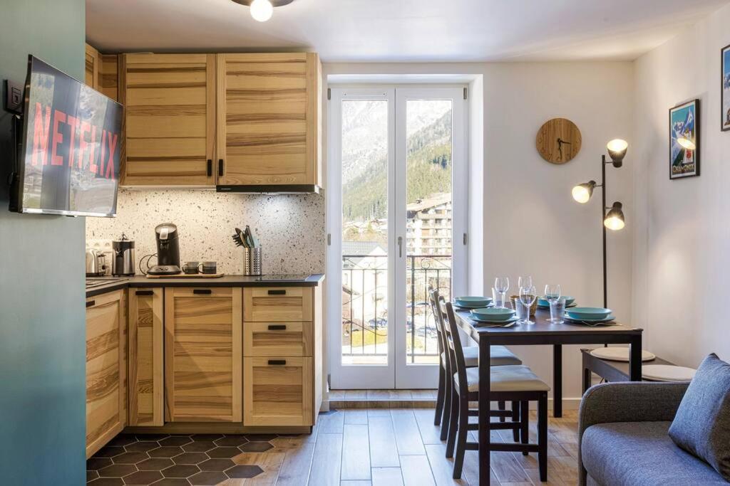 a kitchen and a dining room with a table and a kitchen at Chic 2BR in city center, next to Train Station in Chamonix