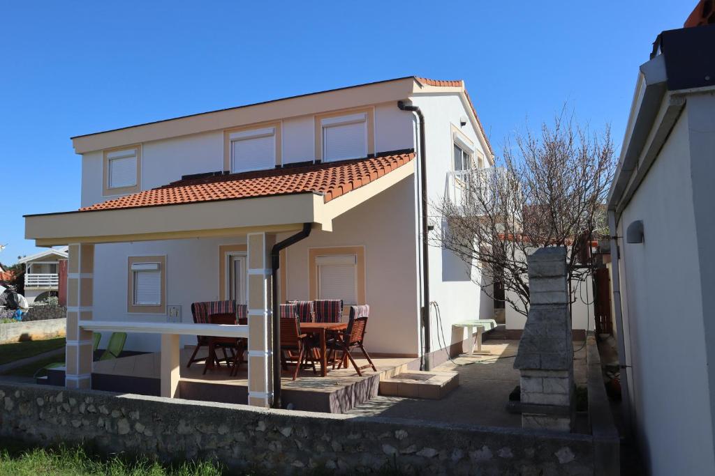 a house with a table and chairs in front of it at Vila Legac - Vir in Vir