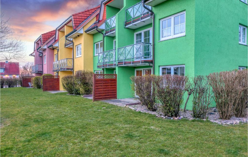 un colorido edificio de apartamentos con arbustos delante de él en Fewo Neuschnberg 2, Og, en Neu Schönberg