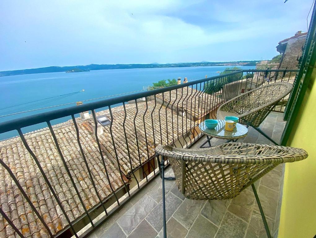 einen Balkon mit einem Tisch und Blick auf das Wasser in der Unterkunft Casa Clemy Lago di Bolsena in Capodimonte