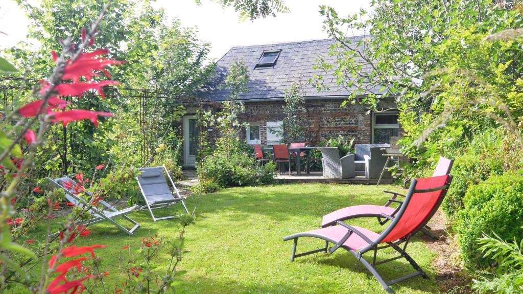 a yard with two lawn chairs and a house at Le Cottage in Bordeaux-Saint-Clair
