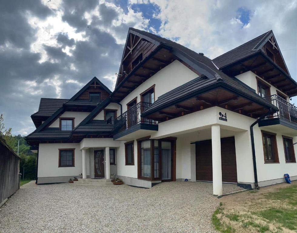 a white house with a black roof at Pokoje u Basi in Sromowce Niżne